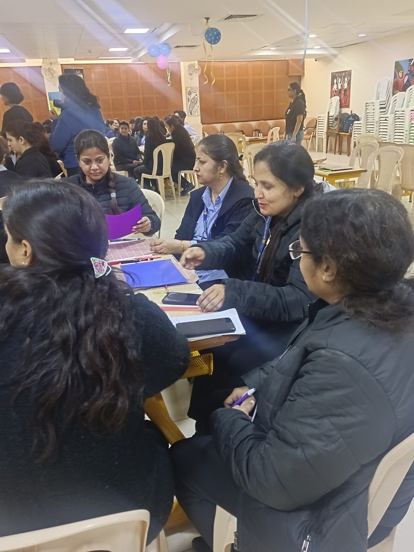 Teachers working together at a table during a hands-on training activity.