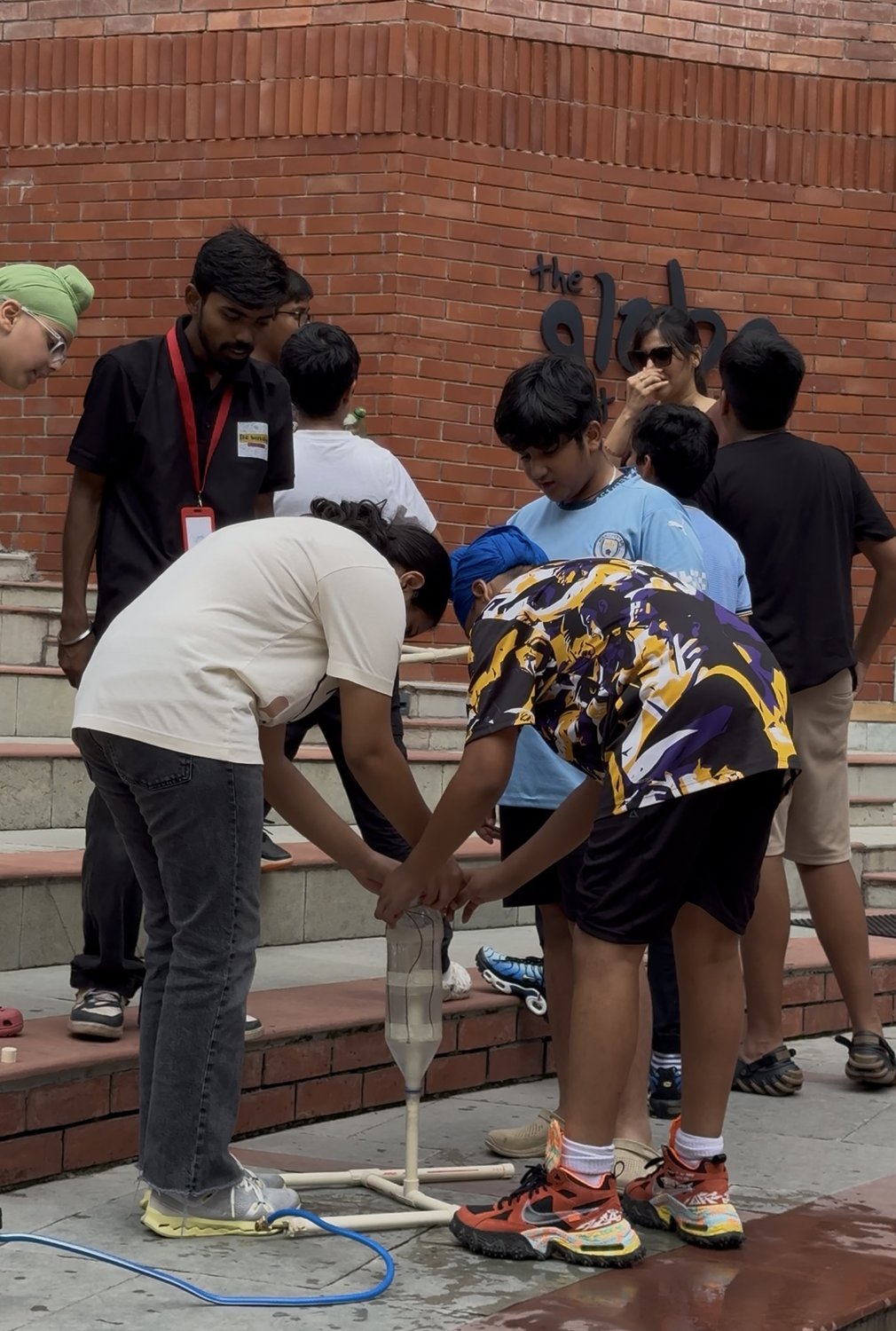 A group of students working together outdoors to set up a water-bottle rocket for launch.