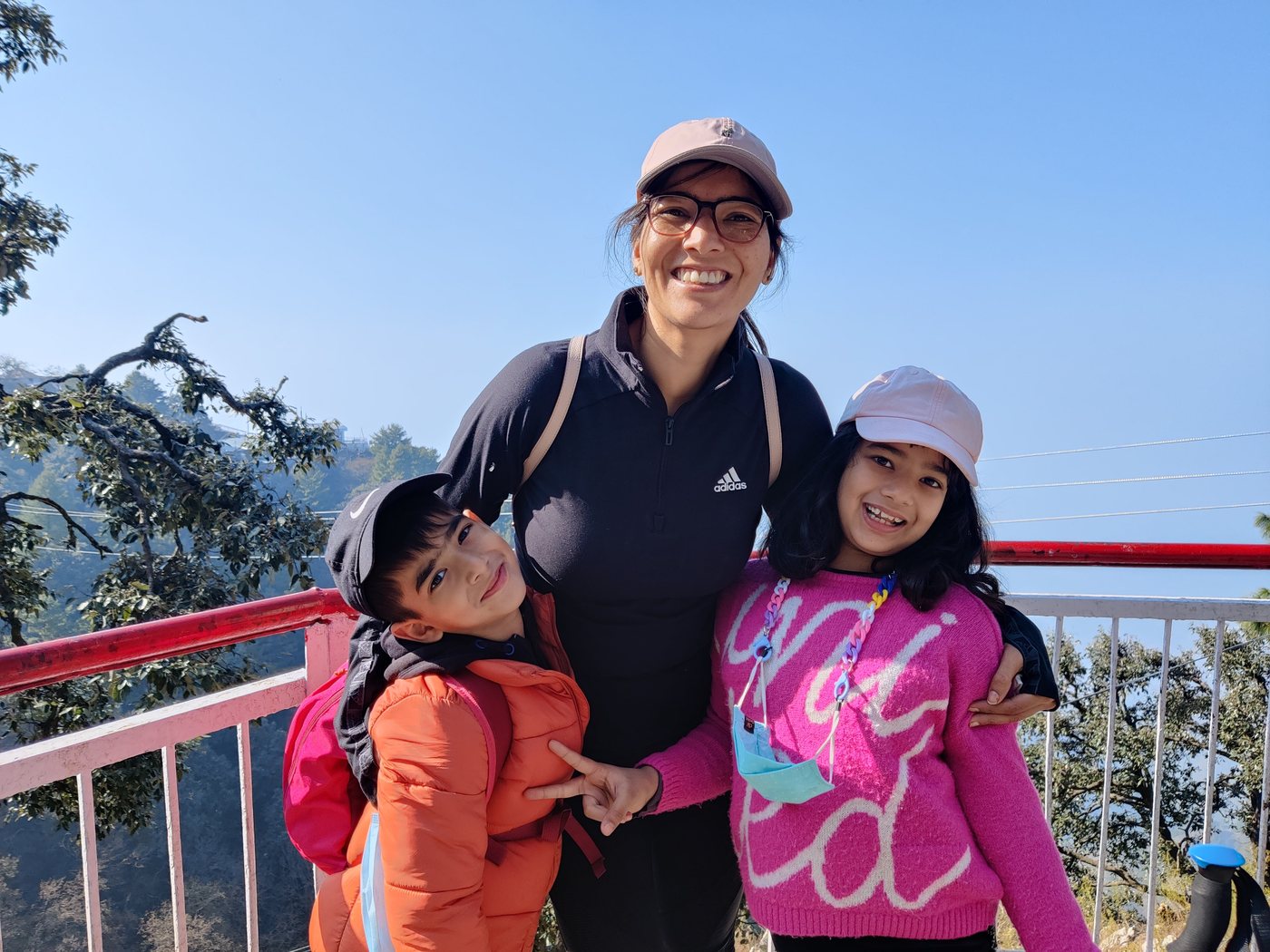 Ritika Khurana, Founder of TheWorkshop, laughing outdoors with her children.